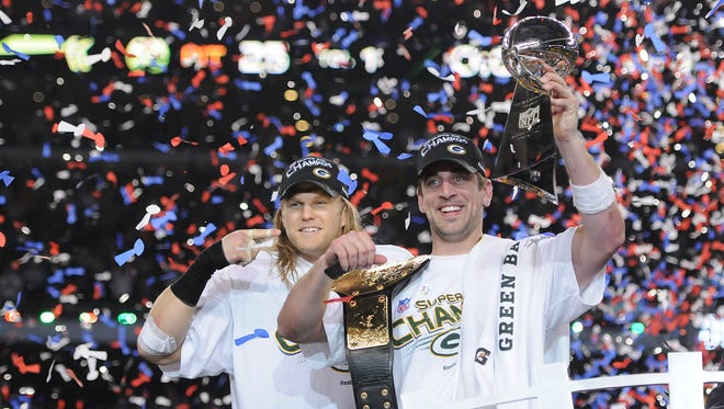 Green Bay Packers linebacker Clay Matthews, left, points to Super Bowl MVP Aaron Rodgers after giving him a championship belt as they celebrate winning Super Bowl XLV over the Pittsburgh Steelers on Feb. 6, 2011.