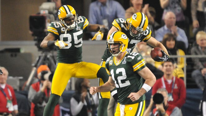 Green Bay Packers quaterback Aaron Rodgers cheers as receivers Greg Jennings, left, and Jordy Nelson, right, celebrate Nelson's touchdown in the first quarter against the Pittsburgh Steelers in Super Bowl XLV on Feb. 6, 2011.