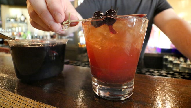 Bar manager Adam Nobs adds a garnish of Louxardo marinated cherries to Pewaukee's Artisan 179 version of the classic Old-Fashioned that the locals call Ron and Mary's Brown Mumbler.