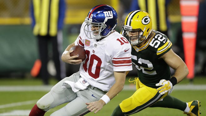 Green Bay Packers outside linebacker Clay Matthews (52) dives on to quarterback Eli Manning (10) against the New York Giants on Oct. 9 at Lambeau Field.