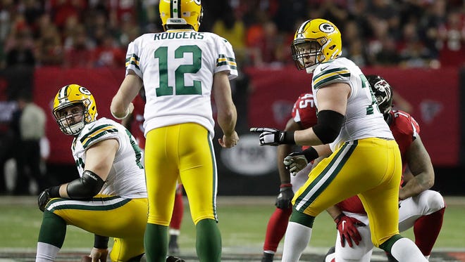 Green Bay Packers guard T.J. Lang (70) and center Corey Linsley (63) look to quarterback Aaron Rodgers (12) for instructions against the Atlanta Falcons at the Georgia Dome in Atlanta, Georgia Sunday, January 22, 2017.
