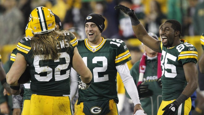 Green Bay Packers quarterback Aaron Rodgers, center, and receiver Greg Jennings, right, congratulate linebacker Clay Matthews as he returns to the sideline after intercepting a pass and running it in for a touchdown against the Dallas Cowboys on Nov. 7, 2010, at Lambeau Field.