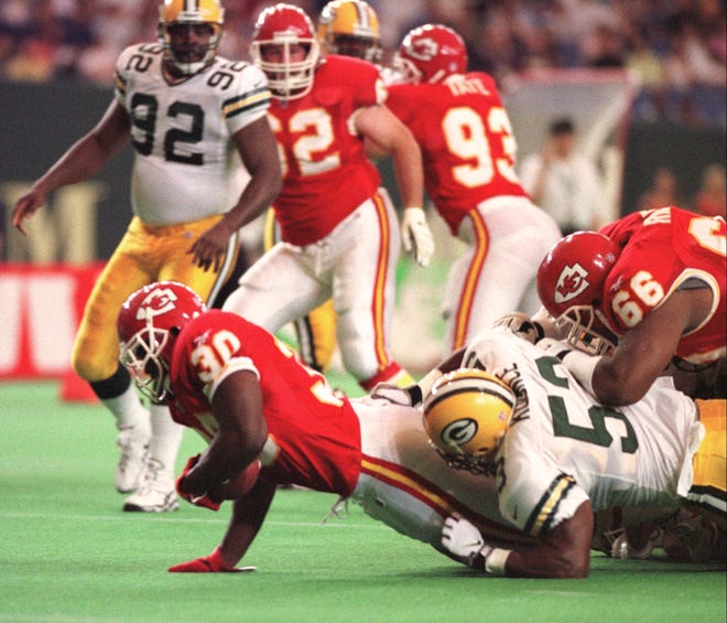 Kansas City Chiefs running back Donnell Bennett (30) is tackled by Green Bay Packers linebacker George Koonce (53) as Chiefs tackle Victor Riley (66) tries to stop Koonce during first quarter action of the American Bowl at the Tokyo Dome in Tokyo, Japan on Aug. 2, 1998. Looking on are: Chiefs defensive end Dan Williams (92), Packers guard Marco Rivera (62) and Packers defensive tackle Gilbert Brown (93).