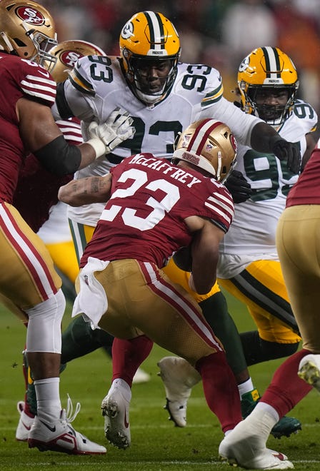Green Bay Packers defensive tackle T.J. Slaton (93) stops San Francisco 49ers running back Christian McCaffrey (23) during the first quarter of their NFC divisional playoff game Saturday, January 20, 2024 at Levi’ Stadium in Santa Clara, California.