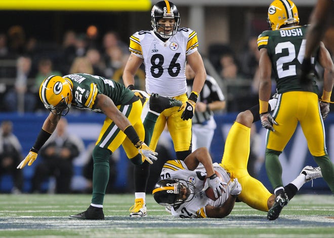 Green Bay Packers cornerback Charles Woodson, left, tackles Pittsburgh Steelers receiver Antwaan Randle El (82) during the second quarter of Super Bowl XLV at Cowboys Stadium in Arlington, Texas on Feb. 6, 2011.