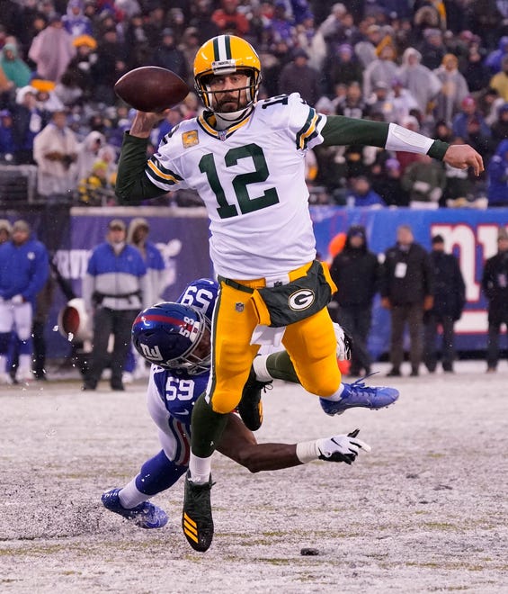 Dec 1, 2019; East Rutherford, NJ, USA; 
Green Bay Packers quarterback Aaron Rodgers (12) breaks free from the grasp of New York Giants linebacker Lorenzo Carter (59) to throw a fourth quarter TD pass at MetLife Stadium. Mandatory Credit: Robert Deutsch-USA TODAY Sports