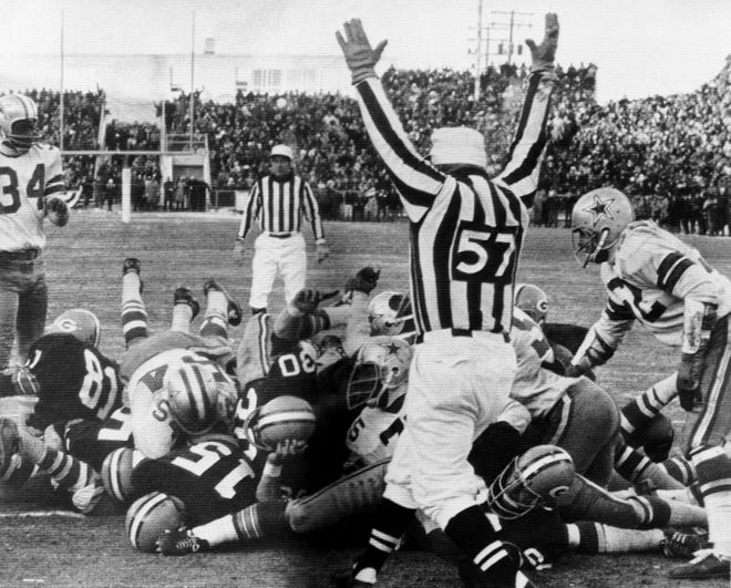 Green Bay Packers quarterback Bart Starr (15) digs his face across the goal line to score the winning touchdown against the Dallas Cowboys to bring the Packers their third consecutive NFL championship, in Green Bay, Wis. The 1967 NFL Championship game was played in such frigid conditions at Lambeau Field that it is known in league annals as the “Ice Bowl.”