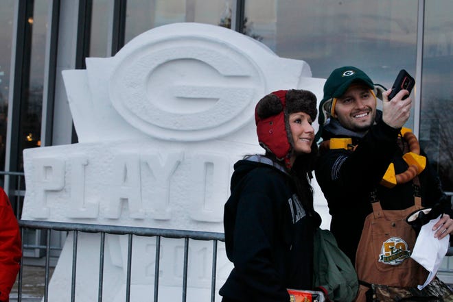 "I've never been to an NFL football game," said Laura Manydeeds and Chris Ruebl, both from Eau Claire as they take a picture outside snow sculptures at Lambeau Field before the NFL playoff game between the Green Bay Packers and Minnesota Vikings, Saturday, December 5, 2012 at Lambeau Field in Green Bay, Wisconsin.
