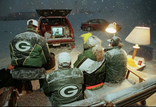 Toby Close, Scott Nielson, Patty Donoghue and Ray Papke, (left to right) all from Green Bay, Wis., watch Super Bowl XXXII in the parking lot of Lambeau Field on Sunday, Jan. 25, 1998.