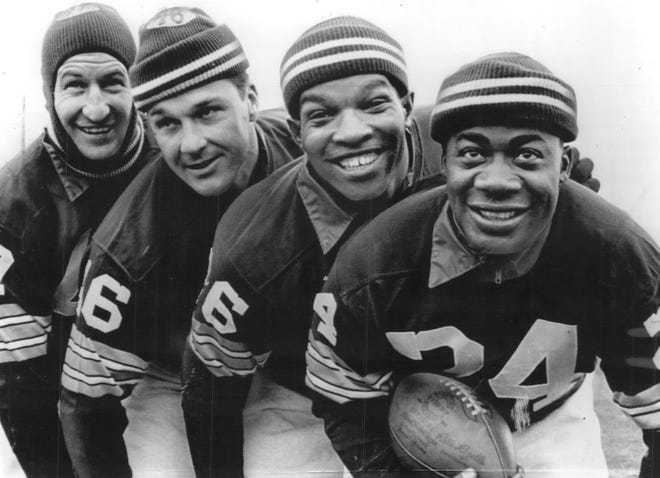 Four cool Green Bay Packer football players were dressed for the chilly 30-degree temperatures as the team began its drills for their Chicago Bear game.  Left to right:  Jesse Whittenton (halfback) Hank Gremminger (halfback) Herb Adderley (halfback) and Willie Wood (halfback).