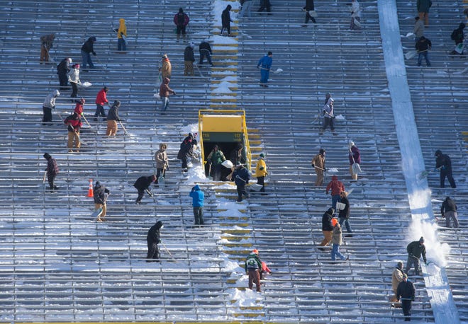 More the 500 people showed up to shovel the four inches of snow inside Lambeau Field on Friday, January 9, 2015 in Green Bay, Wis. The people who turned out were paid $10 an hour for their efforts in preparation for Sunday's divisional playoff game between the Green Bay Packers and the Dallas Cowboys.