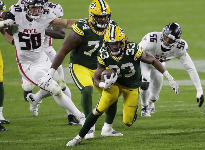 Green Bay Packers running back Aaron Jones (33) runs for a gain against the Atlanta Falcons during their football game Monday, October 5, 2020, at Lambeau Field in Green Bay, Wis.