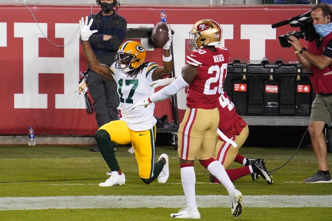 Green Bay Packers wide receiver Davante Adams (17) reacts after catching a pass for a touchdown against San Francisco 49ers cornerback Emmanuel Moseley (41) and free safety Jimmie Ward (20) during the first quarter at Levi's Stadium.