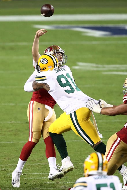 Preston Smith #91 of the Green Bay Packers hits Nick Mullens #4 of the San Francisco 49ers forcing an interception at Levi's Stadium on Nov. 5, 2020 in Santa Clara, California.