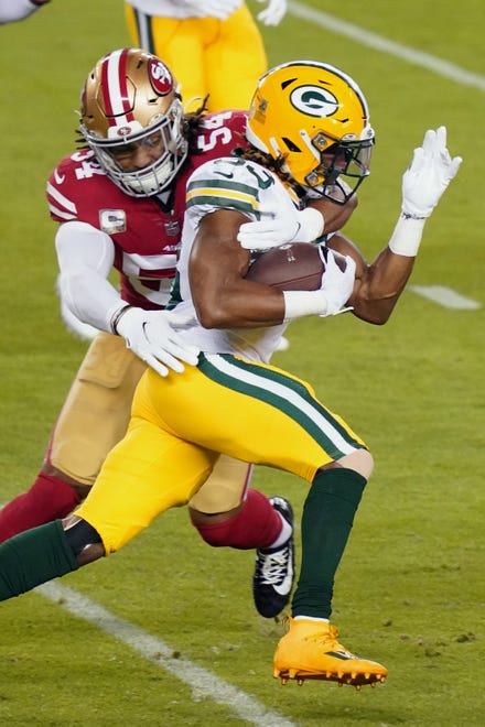Green Bay Packers running back Aaron Jones (33) runs the ball against San Francisco 49ers middle linebacker Fred Warner (54) during the first quarter at Levi's Stadium.