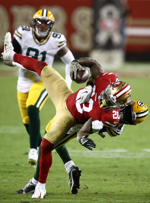 Jerick McKinnon #28 of the San Francisco 49ers is tackled by Josh Jackson #37 of the Green Bay Packers during the third quarter at Levi's Stadium on Nov. 5, 2020 in Santa Clara, California.