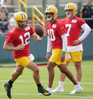 Green Bay Packers quarterbacks Aaron Rodgers (12), Jordan Love (10) and Kurt Benkert (7) participate in training camp on July 28.