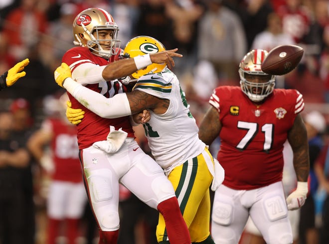 Preston Smith (91) of the Green Bay Packers hits Jimmy Garoppolo #10 of the San Francisco 49ers as he passes during the first half in the game at Levi's Stadium on September 26, 2021 in Santa Clara, California.