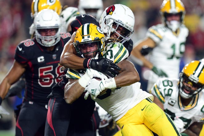Oct 28, 2021; Glendale, Arizona, USA; Green Bay Packers running back Aaron Jones (33) carries Arizona Cardinals linebacker Isaiah Simmons (9) into the end zone for a touchdown during the first half at State Farm Stadium. Mandatory Credit: Joe Camporeale-USA TODAY Sports
