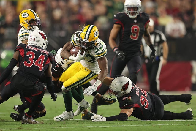 GLENDALE, ARIZONA - OCTOBER 28: Aaron Jones #33 of the Green Bay Packers is pursued by Zach Allen #94 and Jalen Thompson #34 of the Arizona Cardinals during the first half at State Farm Stadium on October 28, 2021 in Glendale, Arizona. (Photo by Christian Petersen/Getty Images)