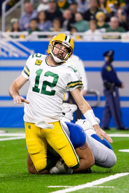 Jan 9, 2022; Detroit, Michigan, USA; Green Bay Packers quarterback Aaron Rodgers (12) gets taken down by Detroit Lions defensive tackle John Penisini (98) after the throw during the first quarter at Ford Field.
