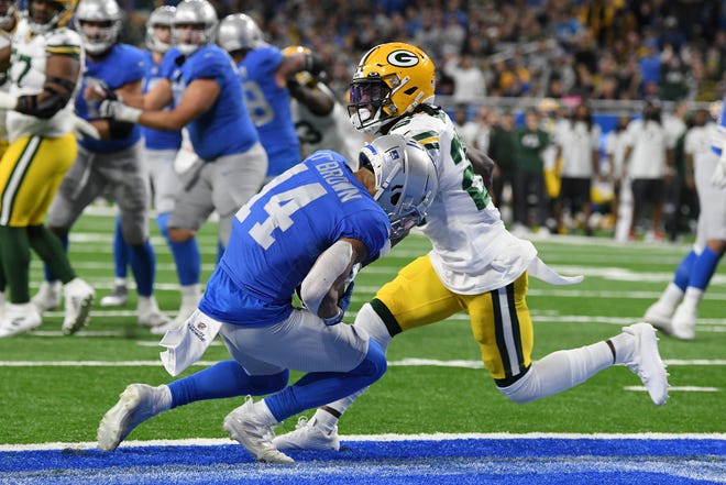 Detroit Lions wide receiver Amon-Ra St. Brown (14), defended by Green Bay Packers free safety Darnell Savage (26) catches a 2-yard pass for a touchdown during the first half of an NFL football game, Sunday, Jan. 9, 2022, in Detroit. (AP Photo/Lon Horwedel) ORG XMIT: otkco110