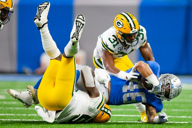 Jan 9, 2022; Detroit, Michigan, USA; Detroit Lions running back Craig Reynolds (46) gets tackled by Green Bay Packers safety Adrian Amos (31) and inside linebacker Krys Barnes (51) during the second quarter at Ford Field.