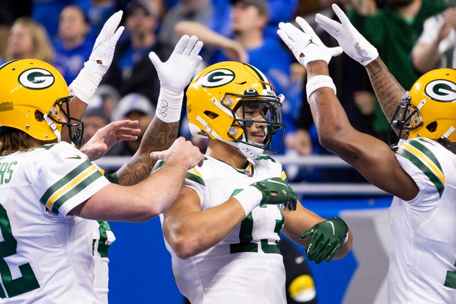 Green Bay Packers wide receiver Allen Lazard (13) gets congratulated by quarterback Aaron Rodgers (left) and wide receiver Davante Adams (right) after a touchdown reception during the first quarter against the Detroit Lions on Jan. 9, 2022, at Ford Field.