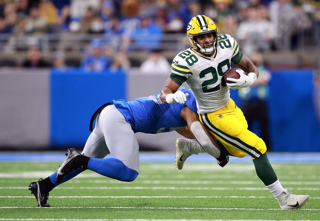 DETROIT, MICHIGAN - JANUARY 09: A.J. Dillon #28 of the Green Bay Packers carries the ball against the Detroit Lions during the first quarter at Ford Field on January 09, 2022 in Detroit, Michigan.