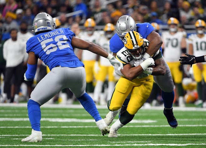 DETROIT, MICHIGAN - JANUARY 09: A.J. Dillon of the Green Bay Packers carries the ball against the Detroit Lions during the first quarter at Ford Field on January 09, 2022 in Detroit, Michigan.