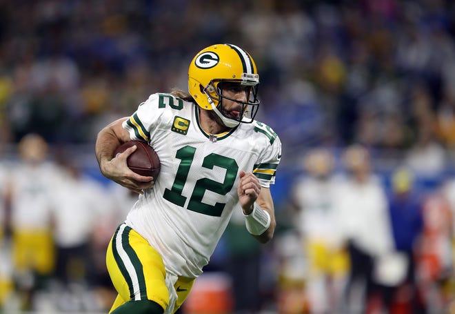 DETROIT, MICHIGAN - JANUARY 09: Aaron Rodgers of the Green Bay Packers carries the ball against the Detroit Lions during the first quarter at Ford Field on January 09, 2022 in Detroit, Michigan.