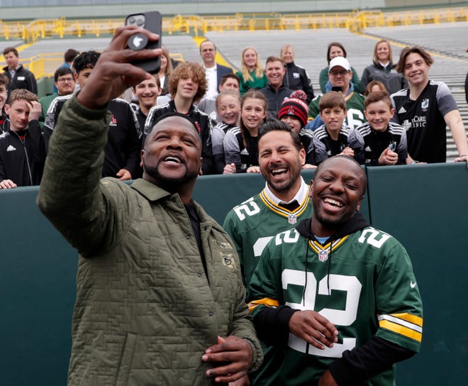 Green Bay Packers Hall of Famer LeRoy Butler takes a video with former FC Bayern Munich player Claudio Pizarro and former Manchester City player Shaun Wright-Phillips on May 2, 2022, after teaching them how to do the Lambeau Leap following an announcement that the two soccer teams will play a match at the stadium this summer.