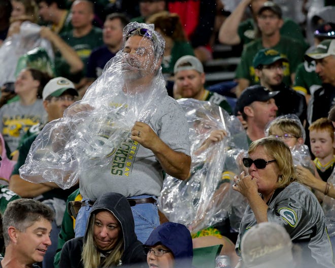 A fan puts on a poncho as rain falls during an NFL preseason football game between the Green Bay Packers and the New Orleans Saints on Friday, August 19, 2022, at Lambeau Field in Green Bay, Wis. The Packers won the game, 20-10.
Tork Mason/USA TODAY NETWORK-Wisconsin