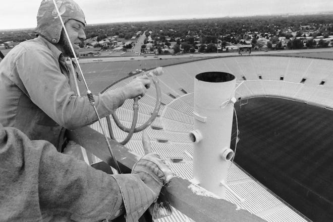 Russel Charles, employed by Modern Painting and Decorating of Green Bay, paints a light pole high atop Lambeau Field in Green Bay, Wis., in July 1979.